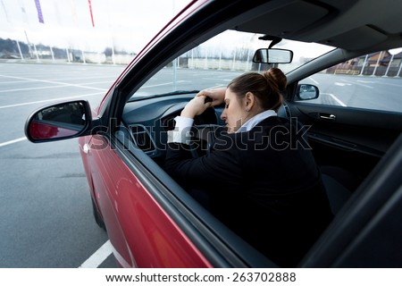 Young tired businesswoman sleeping in car