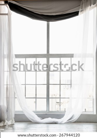 Beautiful high window from ceiling to floor with long white curtains