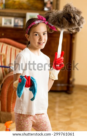 Portrait of teen girl cleaning living room with cloth and feather brush