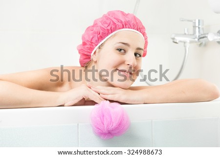 Portrait of young woman in shower cap posing in bath
