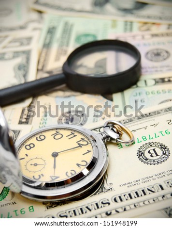 Magnifiers and watch on money.