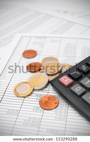 Calculator and coins on the documents