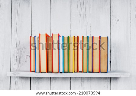 Books on a wooden shelf. On a wooden, white background.