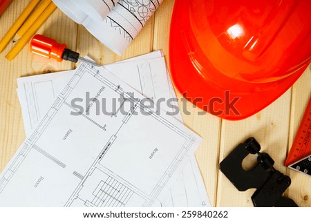 Planning of construction of the house. Repair work. Drawings for building, screwdriver, helmet and others tools on wooden background.