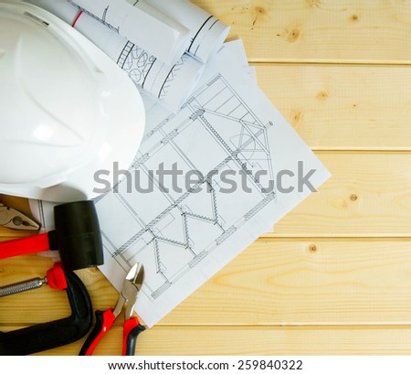 Planning of repair of the house. House construction. Drawings for building, helmet and others tools on wooden background.