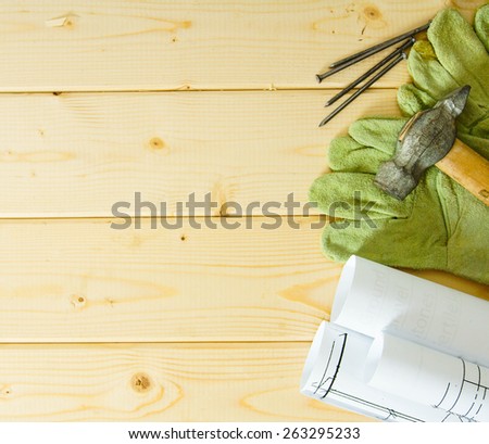 Planning of repair of the house. Repair work. Drawings for building, hammer and gloves on wooden background.