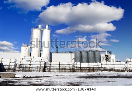 Chemical factory with snow and blue clouded sky