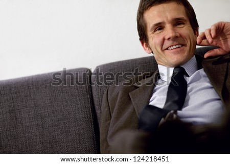 Relaxed businessman on couch in hotel