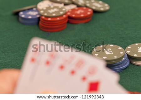 Letter on a green felt poker and play with their chips