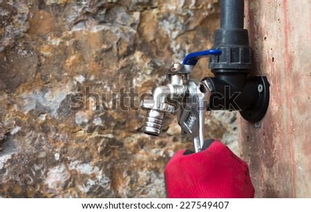 Plumber putting a tap in the yard of a house