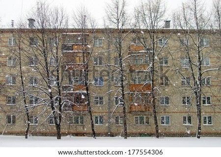 Brick house and a trees in winter, heavy snowfall. Russia