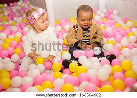 Happy children in colored ball on birthday on playground. The concept of childhood and holiday