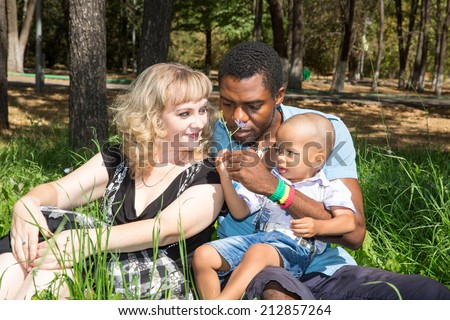 African American happy family: black father, mom and baby boy on nature. Use it for a child, parenting or love concept