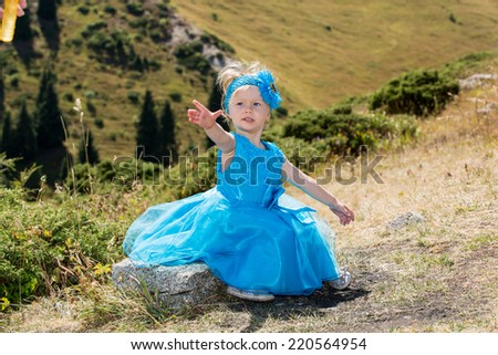 Adorable little child girl on grass on meadow. Summer green nature .  Use it for baby, parenting or love concept