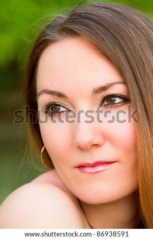 Portrait of the seductive russian woman with long silky hair and  nude shoulder on nature