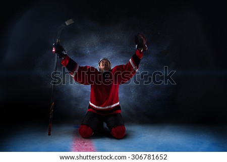 Hockey player sitting on his knees with raised arms