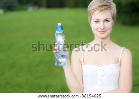 Portrait of lovely girl holding bottle of water in hand