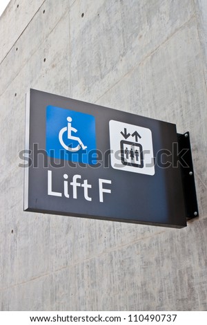 Handicapped wheelchair access logo sign on wall