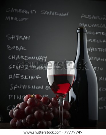 Red grapes, a bottle, a glass of wine and blackboard. Low-angle shot Stockfoto © 