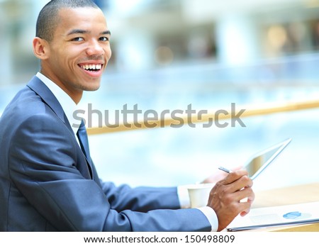 Handsome African American man with tablet computer in modern office