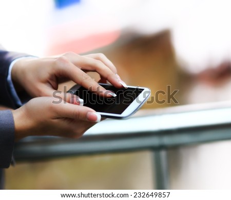 Young beautiful business woman writes an SMS to your mobile phone