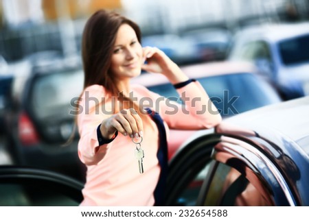 Beautiful young girl with new car key in hand