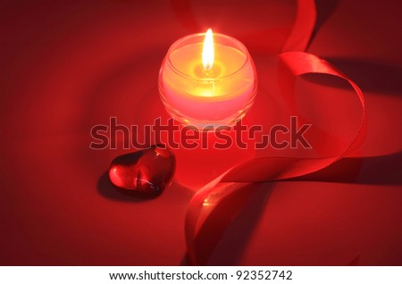 Candle for Valentine\'s Day, weddings, or other events involving love on red background