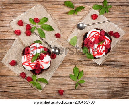 ice cream  with fresh  raspberries and leaves from top on table