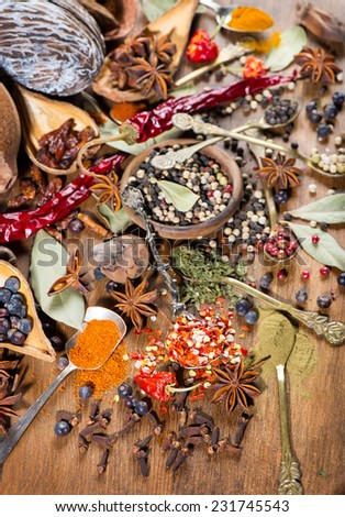Colorful spices and herbs frame on a wooden background. Selective focus.