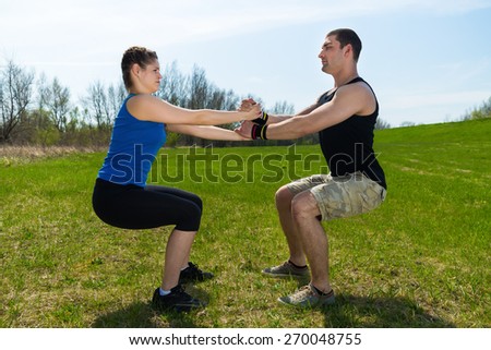 Young woman together with young man in sportswear are doing fitness exercise .