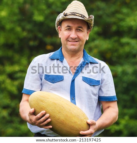 Happy gardener with melon in hands