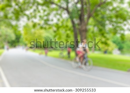 Blurred image of people ride bicycle and jogging in the park