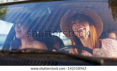 Retro style woman driving old timer car. Traveling with her friends.