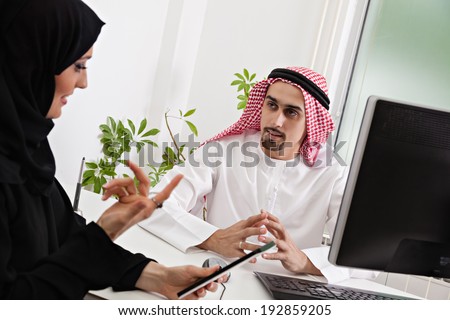 Arabic business couple working in office using tablet and computer.
