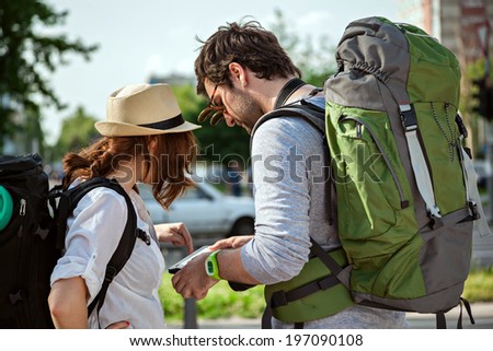 Two Young Tourists With Backpacks Sightseeing City