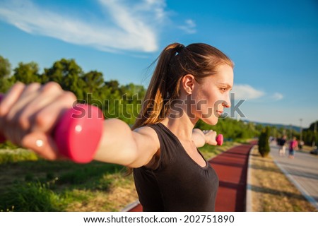 Attractive Young Woman Working Out With Dumbbell. Focus Is On Woman.