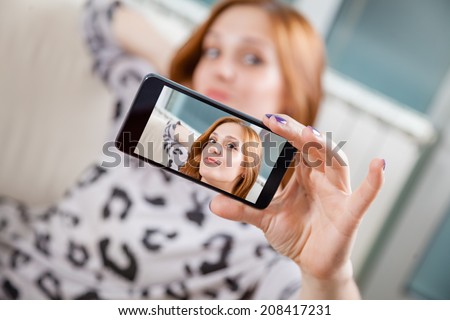 Attractive Woman Taking Selfie Using Smart Phone. Focus Is On Smart Phone