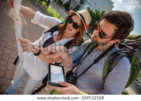 Two Young Tourists With Backpacks Sightseeing City