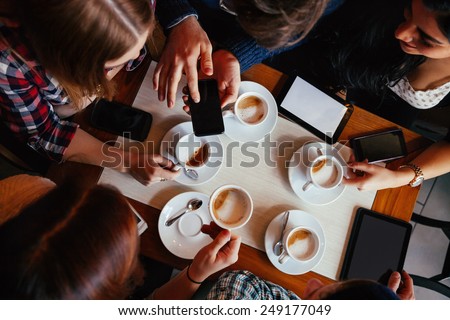 Group Of Young Friends Drinking Coffee In Cafe. View From above