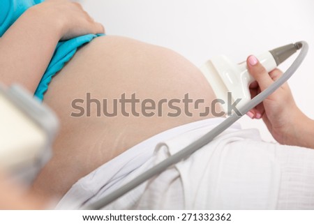 Close Up Pregnant Woman Belly Having An Ultrasound At Doctor's Office