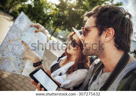 Tourist Couple In The City Browsing Map Using Digital Tablet
