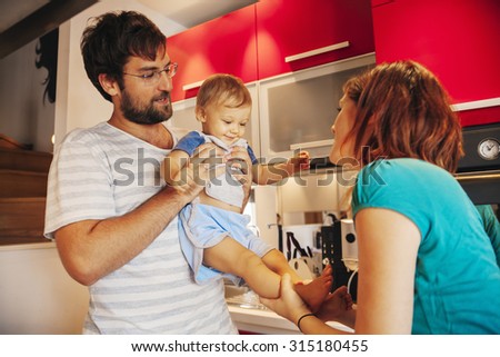 Lovely Couple Entertain Their Son While They Preparing Food
