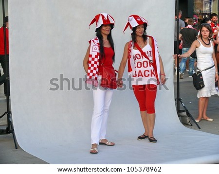 WARSAW, POLAND - JUNE 16: 2 Polish national football fans posing for the national photo before it gets packed for UEFA EURO 2012 football match vs. Czech team, June 16, 2012 in Warsaw, Poland