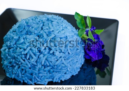 Rice cooked with blue butterfly pea on black plate isolated on white