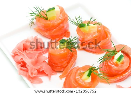 salmon roll with cucumber, cheese and dill and pickled ginger on a white background