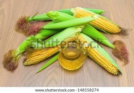 corn on the cob and corn oil in a glass carafe close-up. top view - horizontal photo.