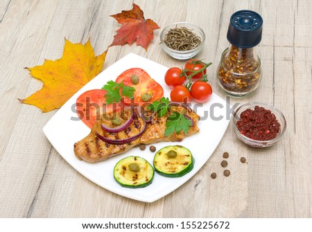 Grilled meat with vegetables on a plate, spices and autumn leaves. horizontal photo.