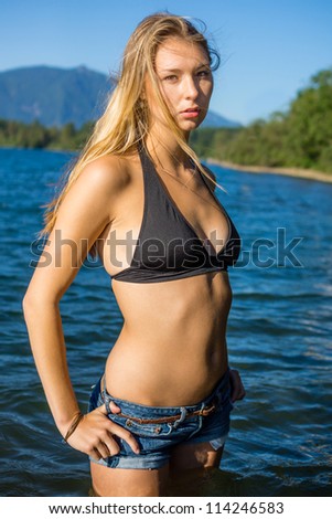 Beautiful Woman in Jean Shorts in Shallow Water