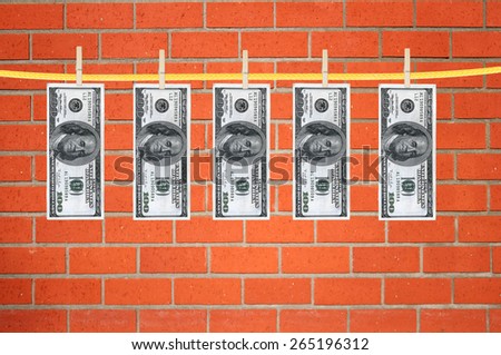 dollars laundering and dry after wash hang on clothespins over orange brick wall