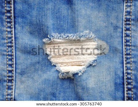 Blue denim jeans in bright color tear up surface condition present the old damaging fabric damaged detail of texture background
